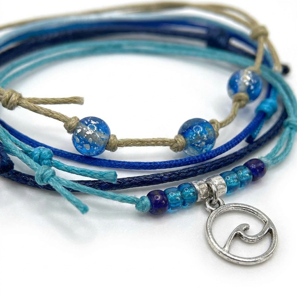 wave bracelet pack close-up with blue glass beads, turquoise and navy cords, beige string and silver-tone wave charm.