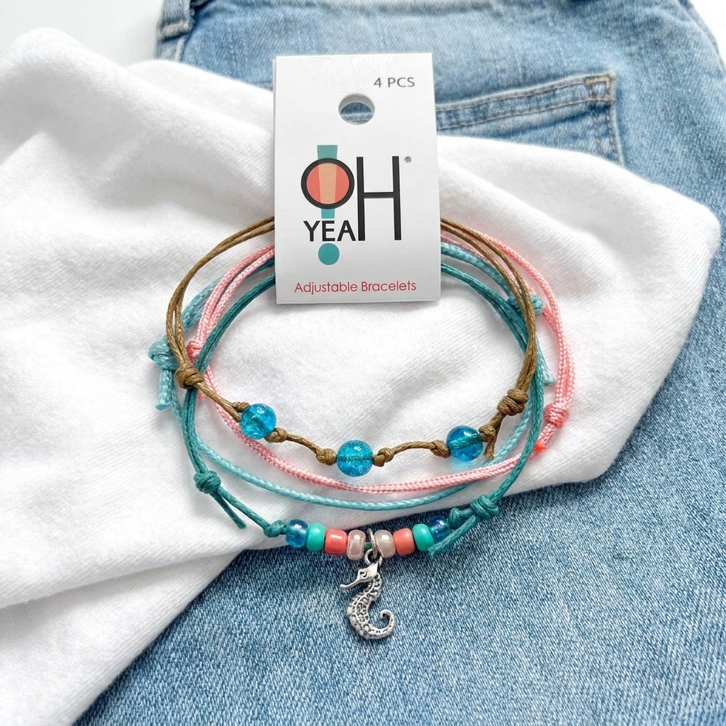 seahorse bracelet pack with O Yeah hang tag, turquoise and pink cords, blue beads and silver charm on white fabric and denim.
