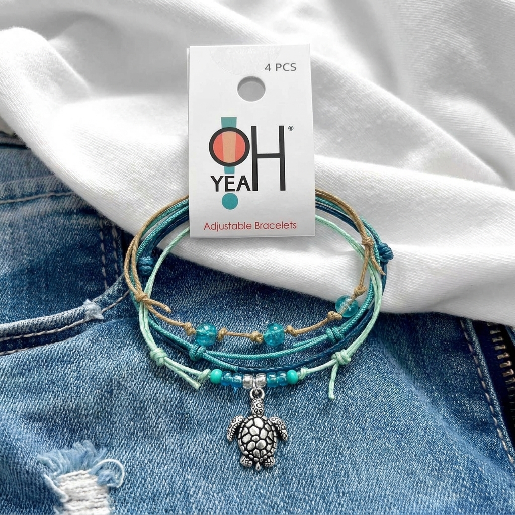 sea turtle bracelet stack with turquoise beads and silver turtle charm on distressed denim beneath an O Yeah display card