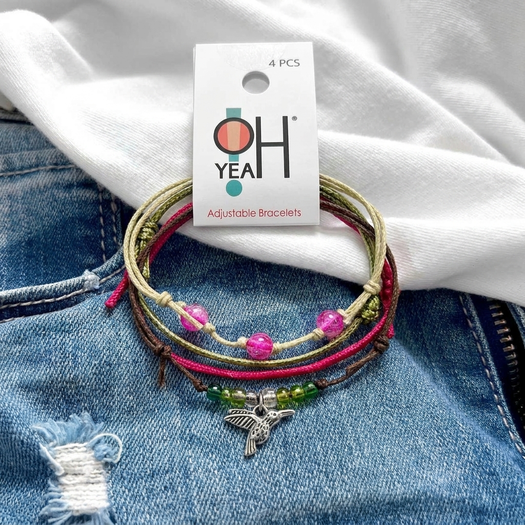 hummingbird bracelet pack with pink and green beads, silver-tone bird charm and O Yeah tag on blue denim.